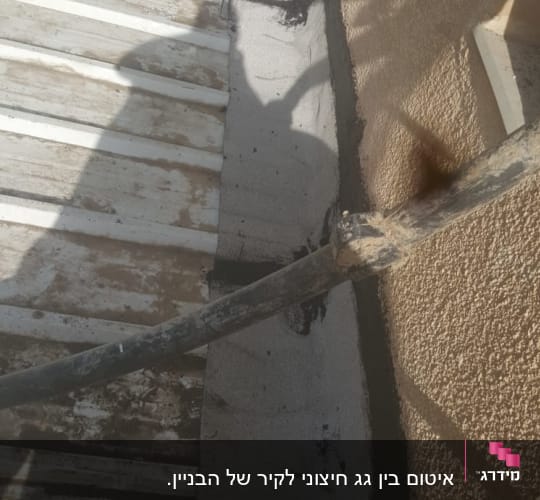גג מתכת עם חומר איטום לאורך הקיר